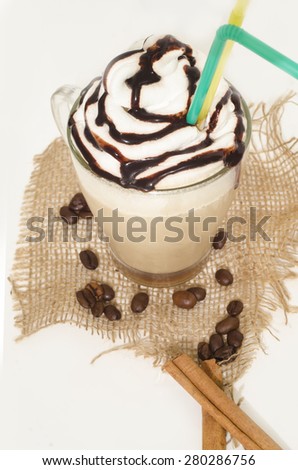 Iced coffee with foam and cinnamon on canvas isolated