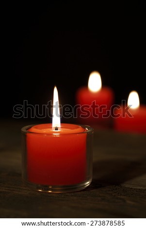 Three candles on the old wooden table,shot with very shallow depth of field.