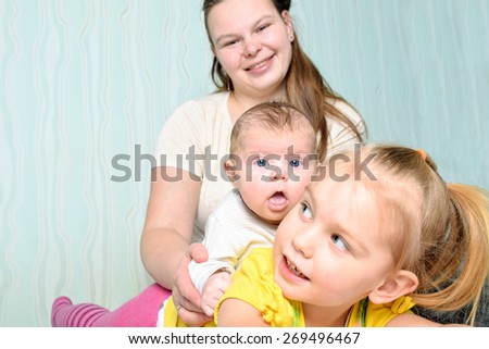 A portrait of a mother and her four years old and three month old baby daughters.