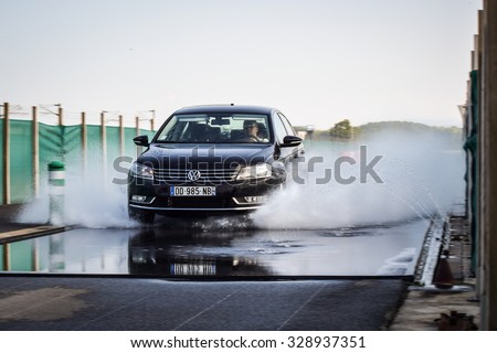 LADOUX, FRANCE - SEPTEMBER 16, 2014: Tire test is held at the proving ground. Test-driver performs a longitudinal aquaplanning test to determine the tire which provides the best grip with wet road.
