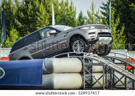 MINSK, BELARUS - JUNE 20, 2015: Test-drive event for 2015 model year Land Rover and Range Rover is held in Minsk, Belarus on June 20, 2015. British SUV Range Rover Sport leaves an artificial pond.