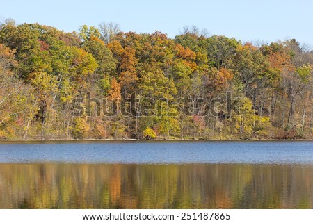 Beautiful fall trees reflect their colors on to fall lake, seasonal natural background
