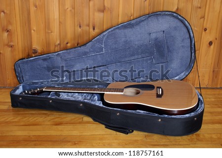 An acoustic guitar in a nice felt lined case.