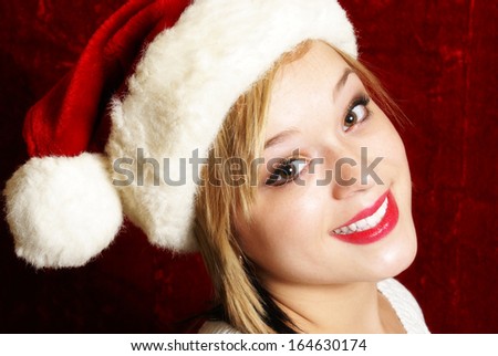 A happy young woman wearing a santa hat for the spirit of Christmas.