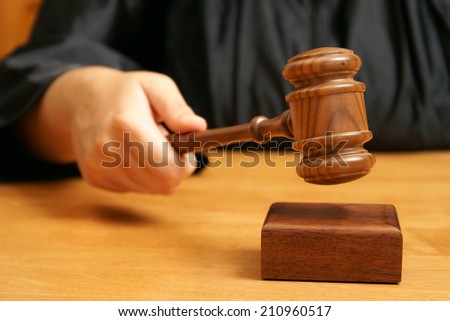 A professional judge declares the legal proceeding with a final hit using the gavel.