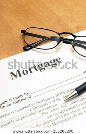 A closeup shot of mortgage papers and glasses to read the fine print.