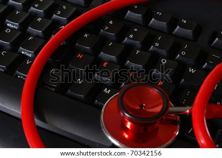 A stethoscope on a keyboard with arranged letters that spell out the word help.