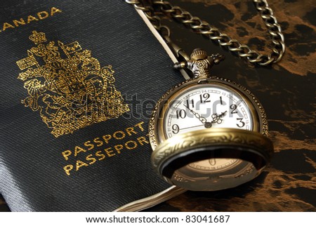An international traveler has a passport and pocket watch ready.