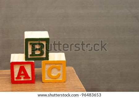 Alphabet blocks in front of the chalkboard for learning the basics of the english language.