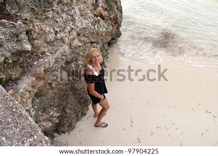 A woman stands at the beach with this high angle shot.