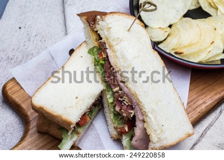 bacon sandwich and potato chips on block