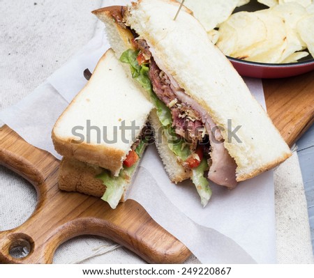 bacon sandwich and potato chips on block