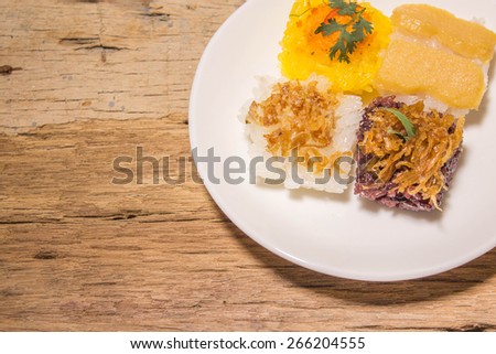Traditional Thai dessert - sweet sticky rice top with steamed egg custard and minced coconut, shrimp,sweet coconut on wooden background