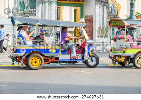BANGKOK - MAY 1: A three wheeled tuk tuk taxi on a street in the Thai capital on MAY 1, 2015 in Bangkok, Thailand. Tuk tuks are commonly used in transporting people and goods around the capital.
