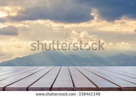 Empty wooden table platform with mountain at morning sunrise background for presentation product.