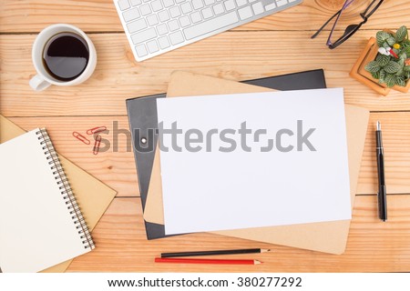Office desk table with smartphone, pen on notebook, cup of coffee and flower. Top view with copy space (selective focus)