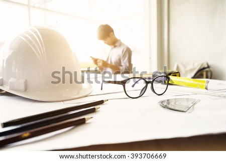 Desk of Engineering project in construction site or office with mining light.Construction concept.Engineering tools.Vintage tone retro filter effect,soft focus(selective focus)