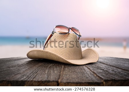 sunglasses and hat on wooden desk