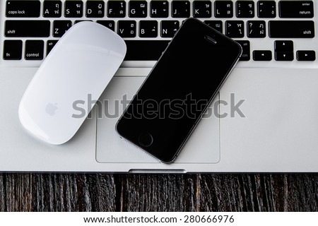 CHIANGMAI, THAILAND -MAY 22, 2015:Iphone 5s, apple mouse and macbook pro on wooden desk