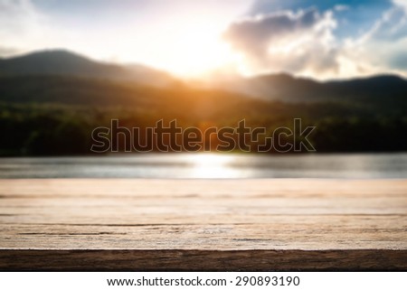 desk space and beautiful river with mountains and sun set background