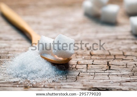 Sugar in wood spoon on old wood table
