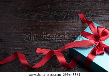 green gift box red bow on wood table, top view