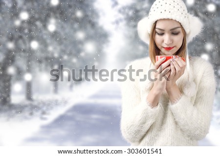 beautiful young woman with cup of coffee and winter snow background