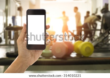 Hand holding smartphone device at gym background