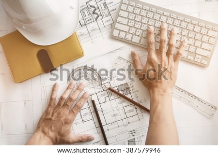 Image of engineer hands working with engineering tool on workplace top view vintage tone.