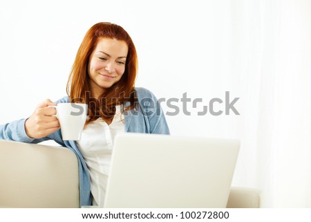 Portrait of a pretty young woman working relaxed on laptop