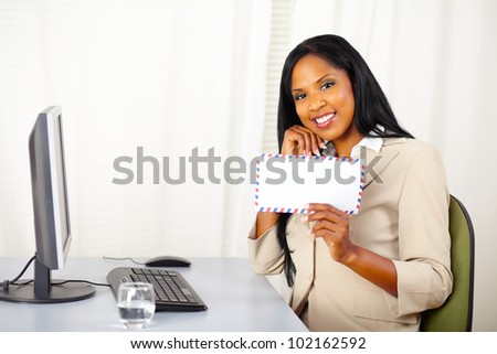 Portrait of a beautiful young businesswoman at work showing a letter to you