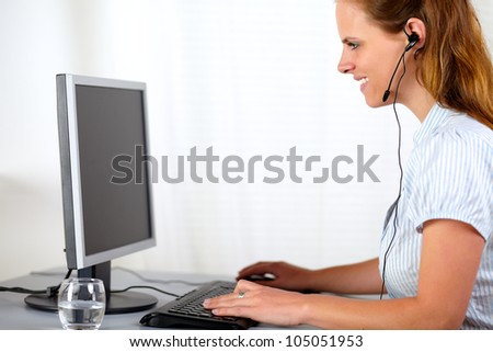 Portrait of a blonde charming lady working on computer at office
