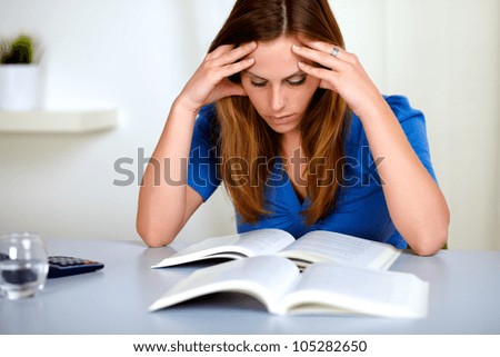 Portrait of a pretty fatigue blonde student girl learning books at home indoor