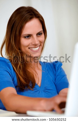 Portrait of a attractive woman writing on laptop at home indoor