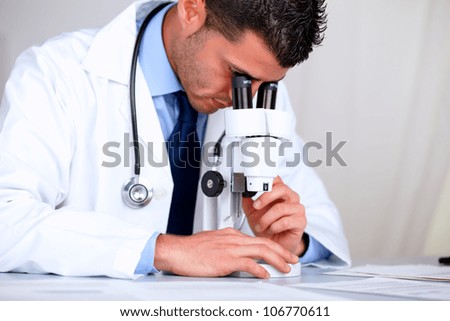 Portrait of a hispanic professional doctor with a microscope at laboratory at hospital indoor
