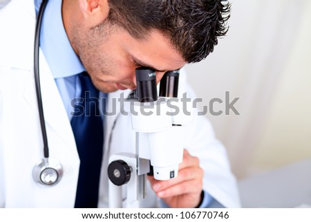 Portrait of a attractive latin doctor using a microscope at hospital indoor