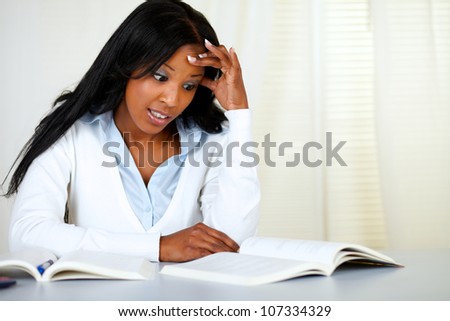 Portrait of a stressed young black woman studying at soft colors composition