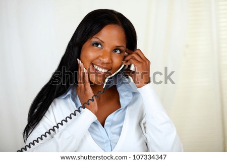 Portrait of a young black lady thinking and conversing on phone