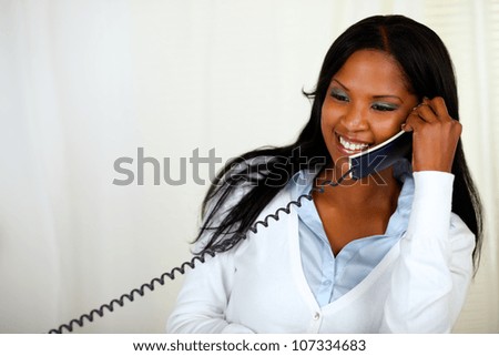 Portrait of a young lovely female laughing and conversing on phone