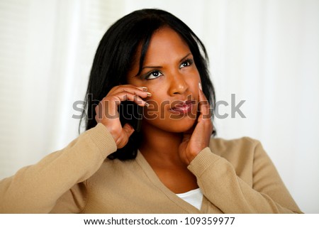 Portrait of a pensive young woman conversing on cellphone