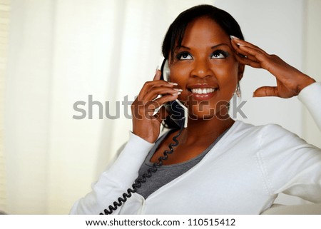 Portrait of a relaxed woman looking up and conversing on phone at soft composition