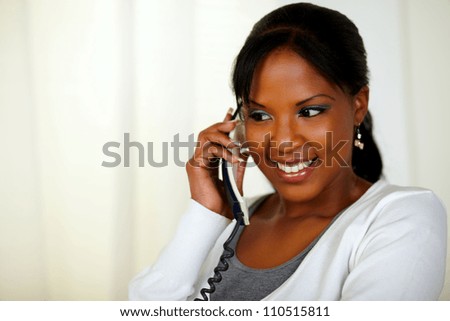Portrait of a relaxed young woman conversing on phone at soft colors composition
