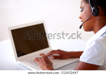Pretty young woman working on customer service with laptop