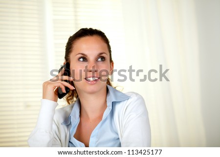 Lovely young woman conversing on cellphone - copyspace