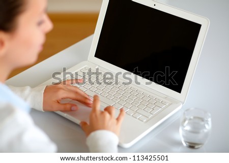 Pretty young woman browsing the internet on her laptop at home