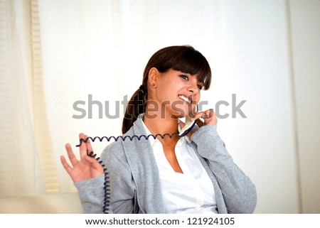 Portrait of a lovely young woman smiling and conversing on phone