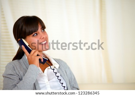 Portrait of a adult woman looking up and speaking on phone - copyspace