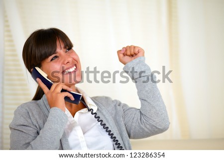 Portrait of a happy young woman speaking on phone and looking up