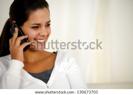 Portrait of a charming young woman conversing on mobile phone