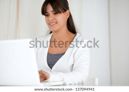 Portrait of a pretty young woman browsing the internet on laptop computer
